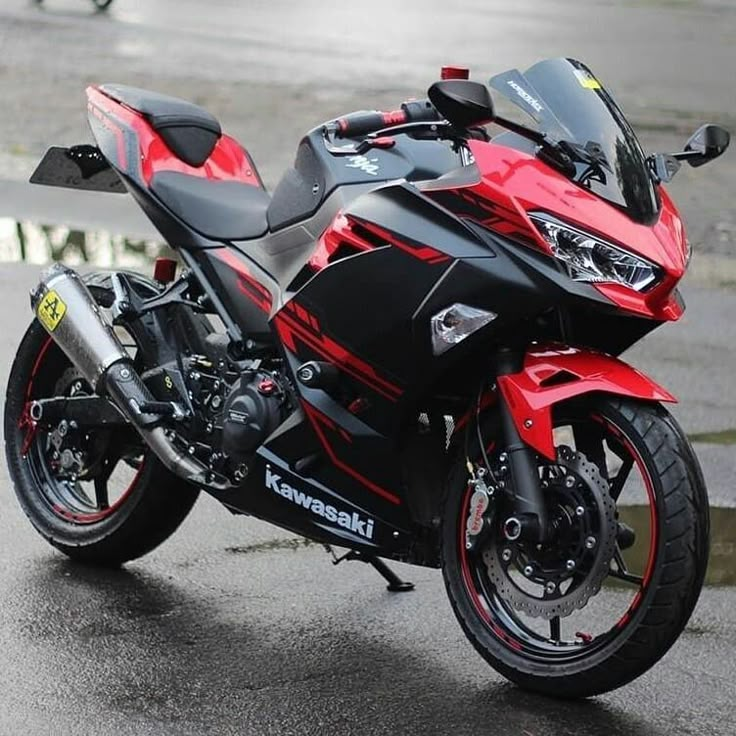 a red and black motorcycle parked on the street