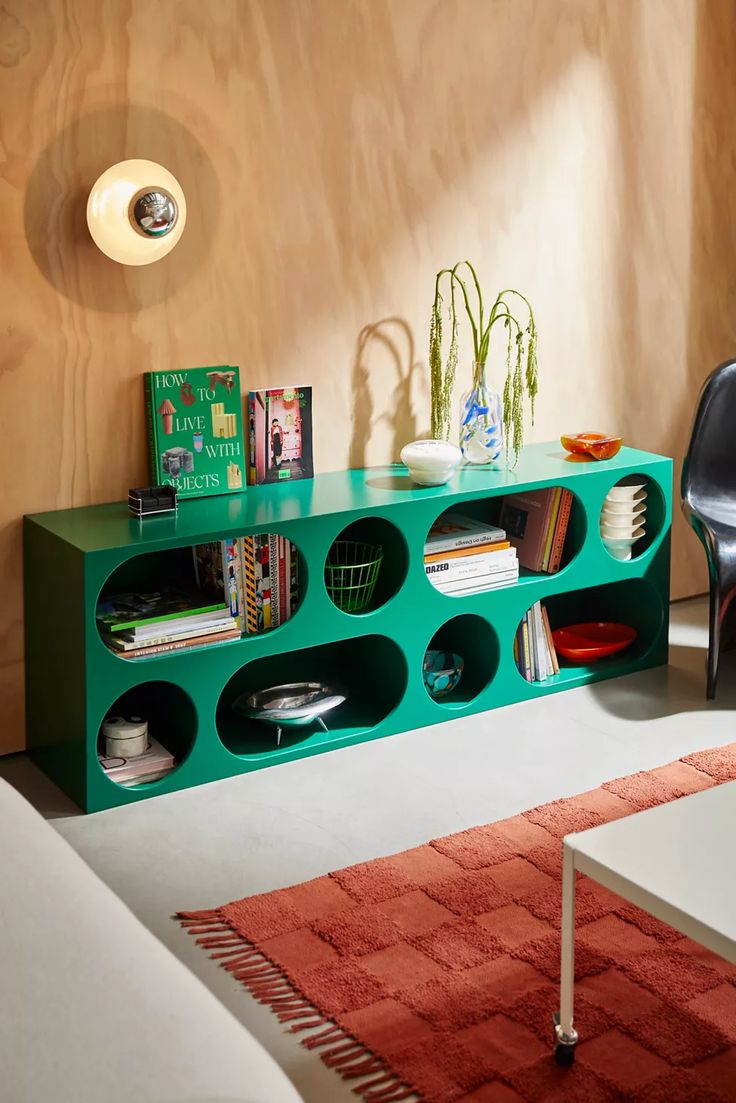 a living room with a green shelf filled with books