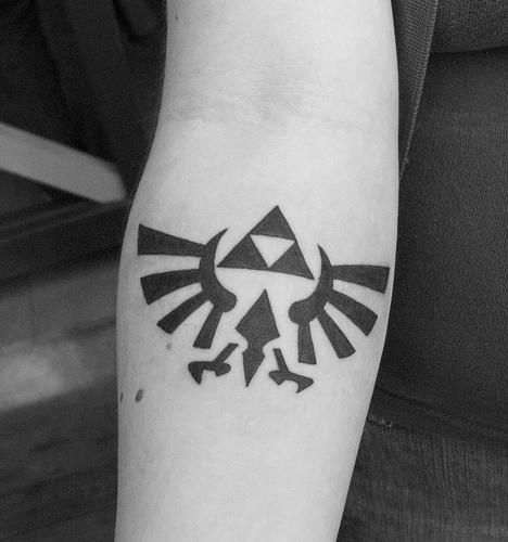 a person with a tattoo on their arm that has the legend of zelda symbol on it