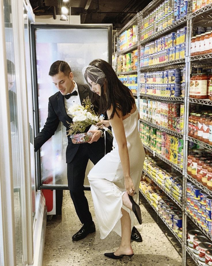 a man in a tuxedo standing next to a woman in a white dress