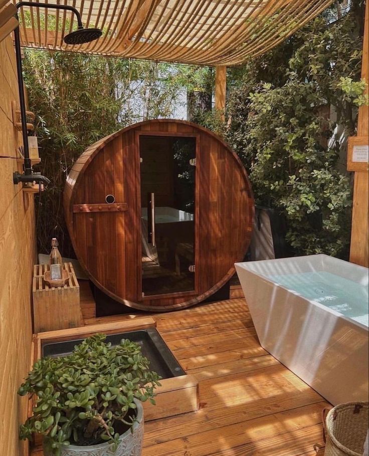 an outdoor jacuzzi tub in the middle of a wooden decked area with potted plants