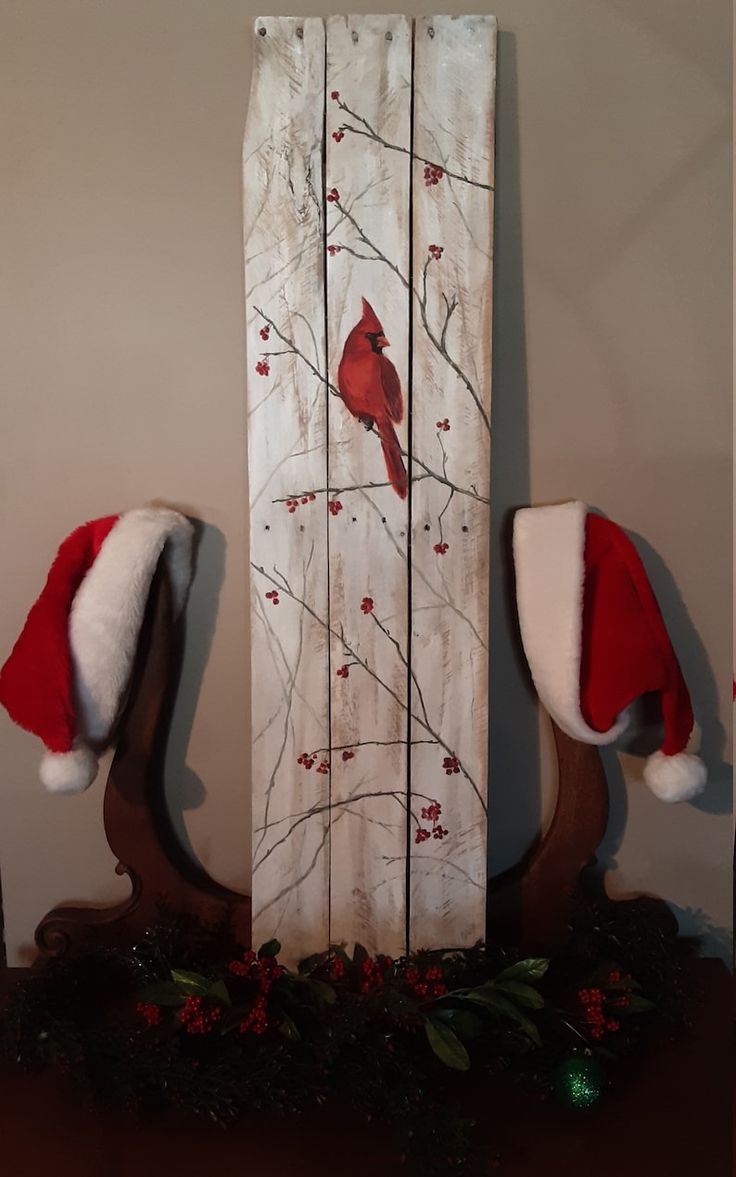 a christmas scene with two red birds on a tree branch and santa's hats