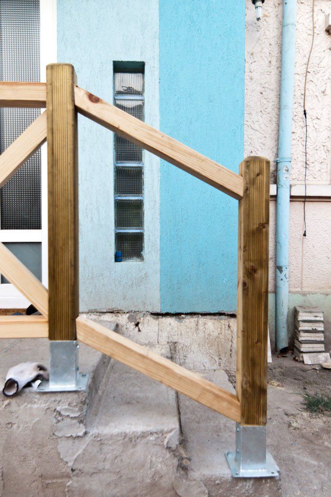 a wooden gate in front of a building with blue paint on the walls and floor