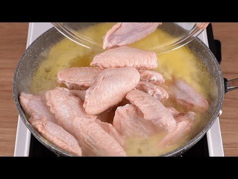 chicken being cooked in a pan on the stove top with yellow liquid and seasoning