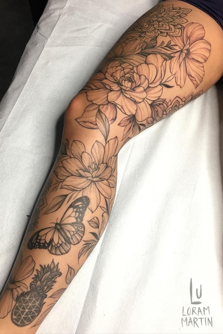 a woman laying on top of a bed next to a white sheet covered in tattoos