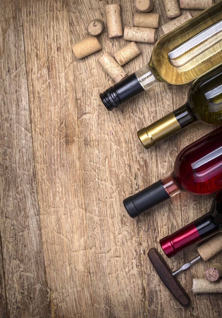 several wine bottles and corks on a wooden table