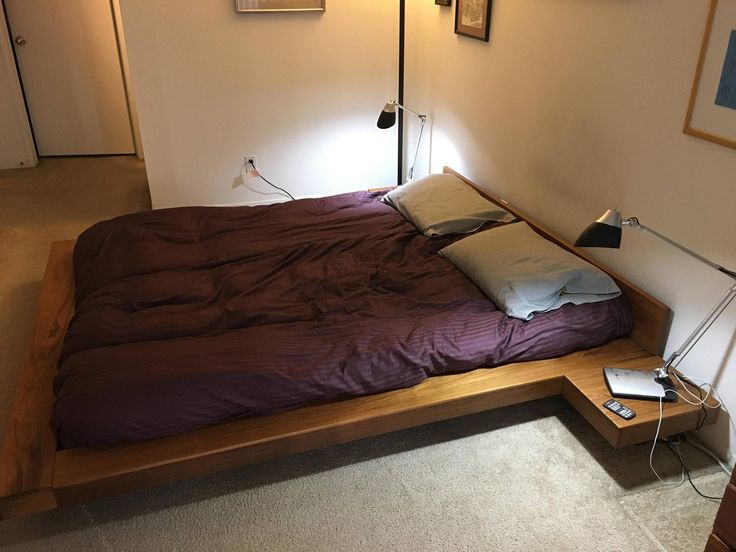 a bed that is made up with a purple comforter and pillows on top of it