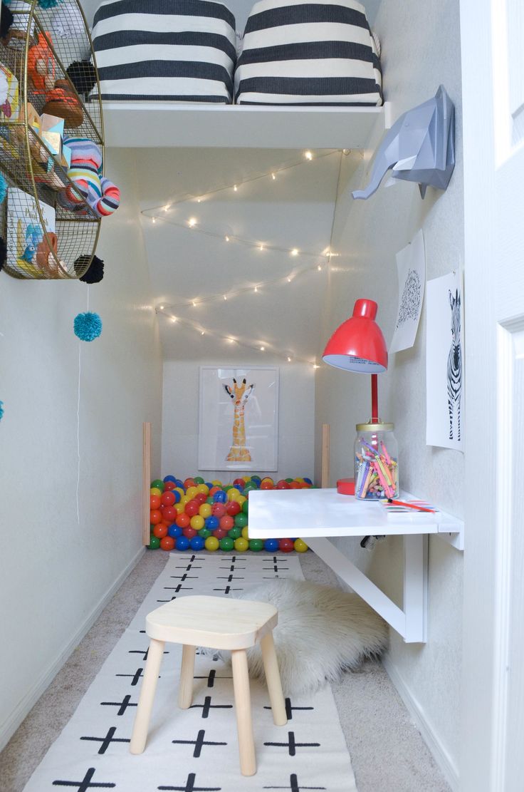 a room with white walls and black and white rugs on the floor next to a desk