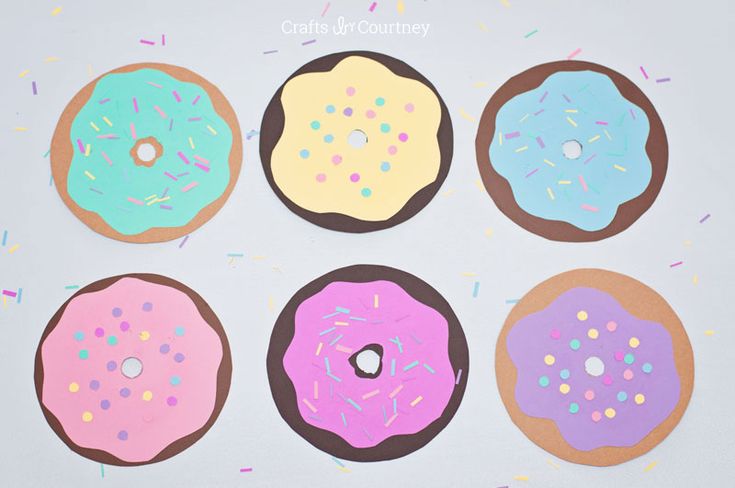 four doughnuts with sprinkles on them are arranged in a circle