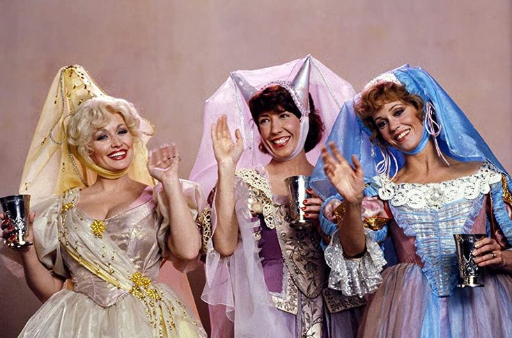 three women dressed in costumes holding up their hands