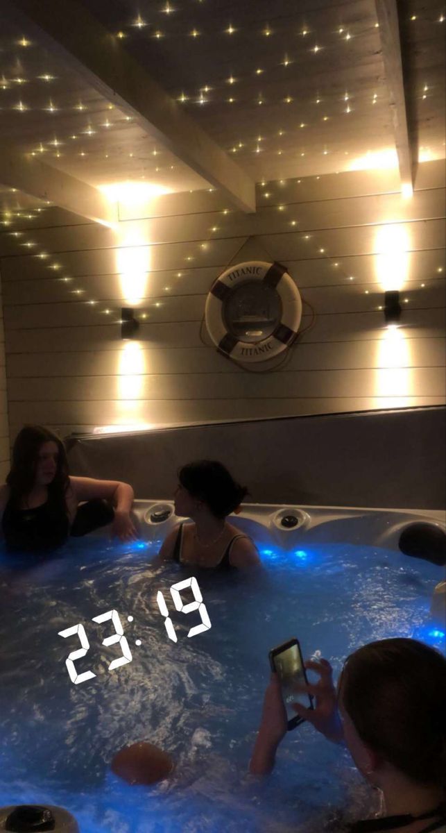 two people sitting in a hot tub with the time displayed on their cell phones next to each other