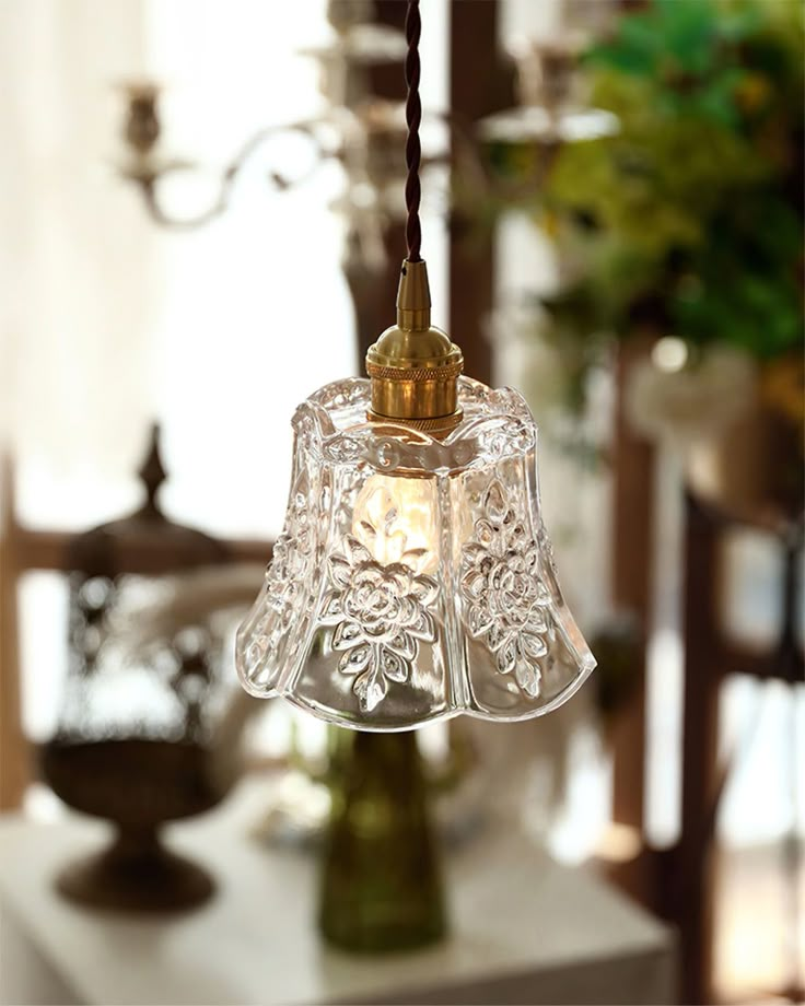 a glass bell hanging from a ceiling in a room with other items on the table