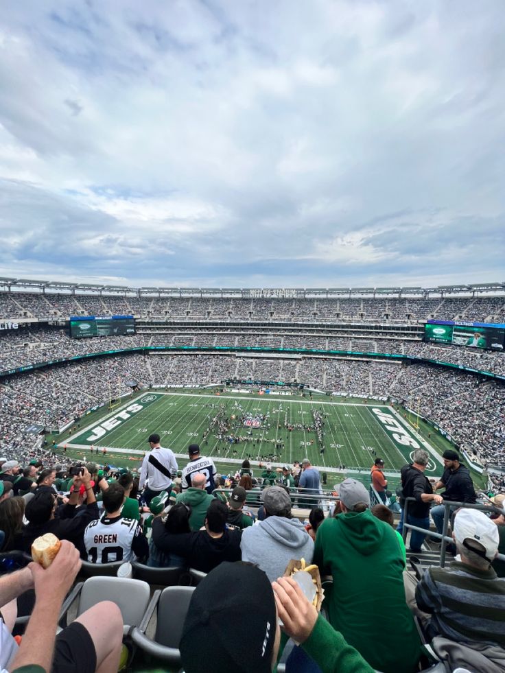 a football stadium filled with lots of people sitting on the bleachers and eating food