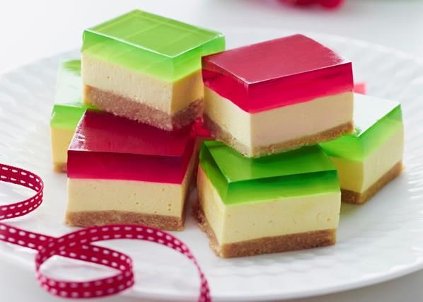 small pieces of cake sitting on top of a white plate with red and green ribbons