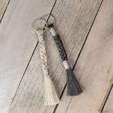 two tasseled key chains sitting on top of a wooden floor