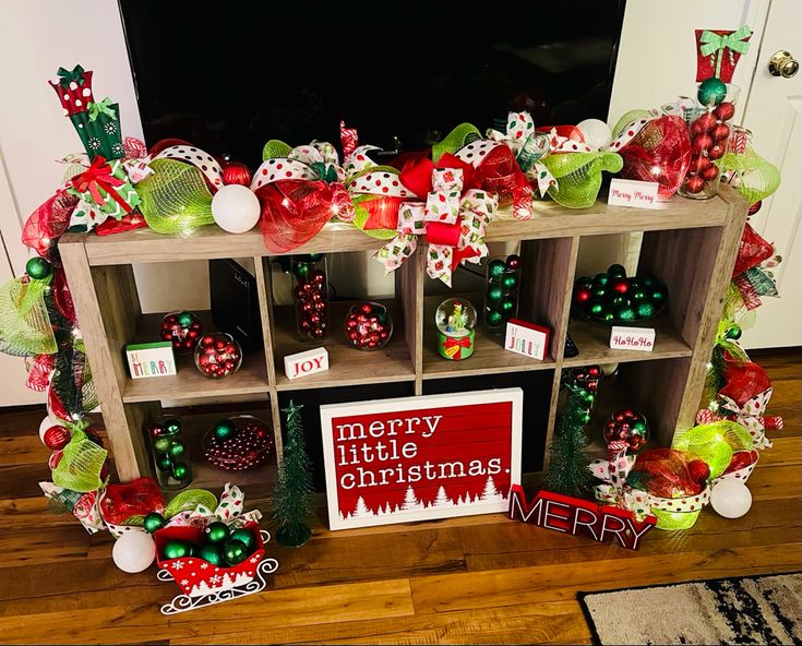 a shelf with christmas decorations on it and a merry little christmas sign next to it