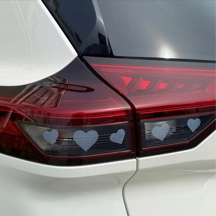 the tail lights of a white car with hearts on it