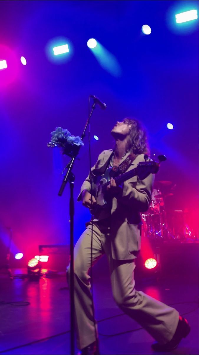 the man is playing his guitar on stage