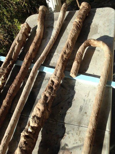 some very old looking wooden sticks laying on top of a cement slab in the dirt