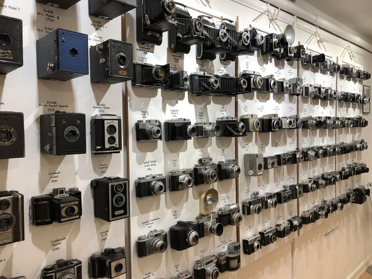 the wall is full of many different types of cameras