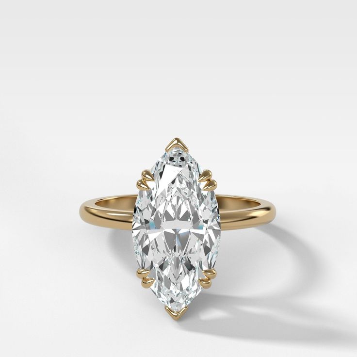 a pear shaped diamond ring with an intricate band around the center and shoulders, set in 18k yellow gold