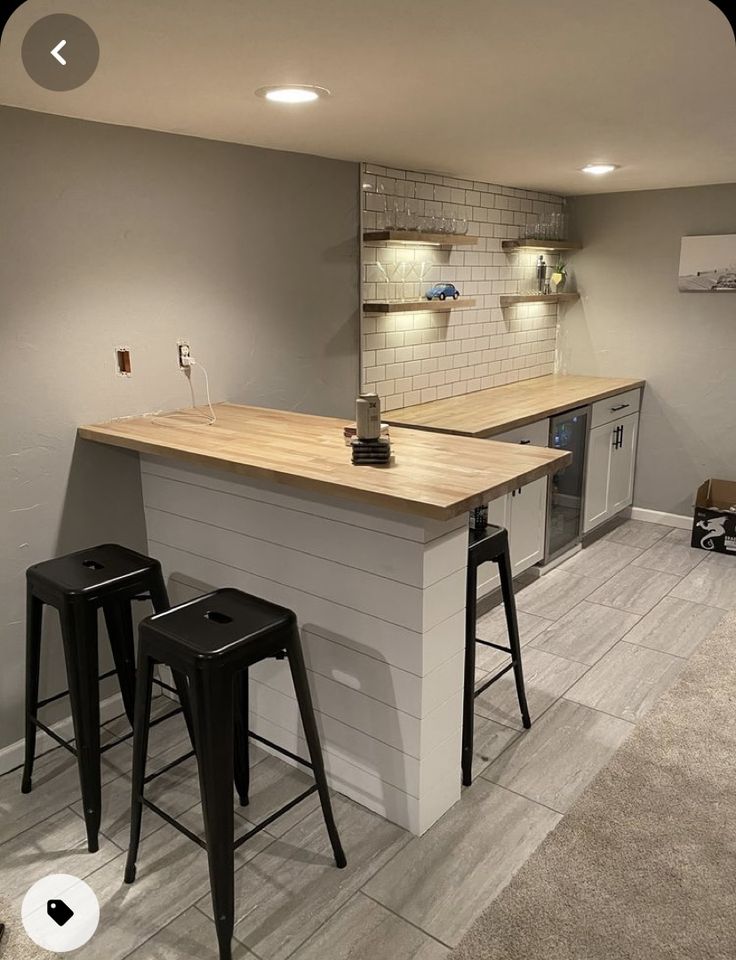 a kitchen with two bar stools next to it