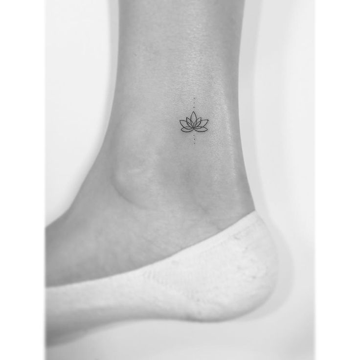 a small lotus tattoo on the ankle