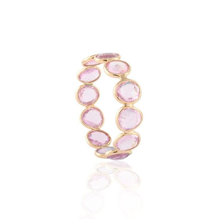 This is part of Chairish’s Fine Jewelry assortment.  Pink sapphire eternity band ring in 18k gold symbolises the everlasting love between a couple. It shows the infinite love you have for your partner. The round shape represents love which will continue and makes your promises stay forever. This pink sapphire eternity band helps those who are looking for love immensely. Lightweight and gorgeous, this is a perfect bridesmaid, wedding gift for anyone on your list. Show your endless love by gifting Round Pink Sapphire Ring With Rose Cut Diamonds, Pink Sapphire Ring With Rose Cut Diamonds, Luxury Stackable Sapphire Ring With Round Band, Stackable Pink Sapphire Ring, Stackable Pink Sapphire Jewelry With Round Band, Pink Sapphire Gemstone Stackable Rings For Anniversary, Pink Sapphire Stackable Rings, Pink Sapphire Promise Ring With Round Band, Anniversary Pink Sapphire Ring With Round Band