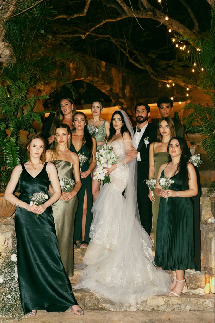 a group of people standing next to each other in front of a stone wall with lights