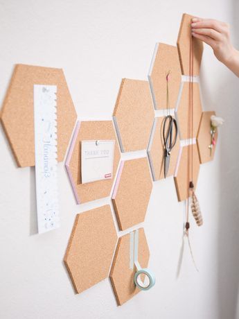 there are several pieces of cork attached to the wall with magnets and paper clips