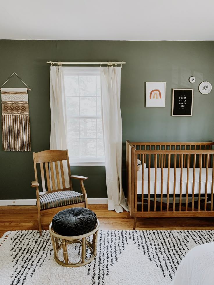 a baby's room with a rocking chair, crib, and window in it