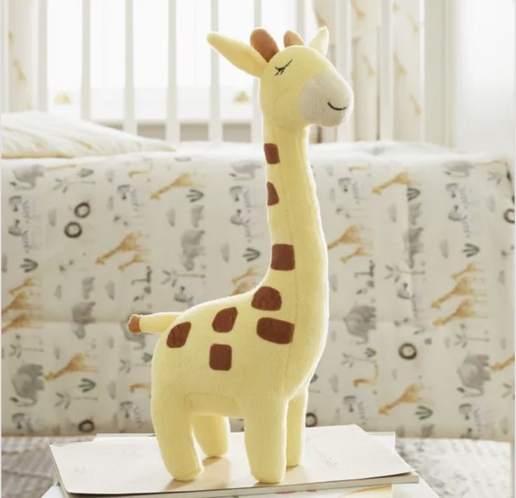 a stuffed giraffe sitting on top of a box