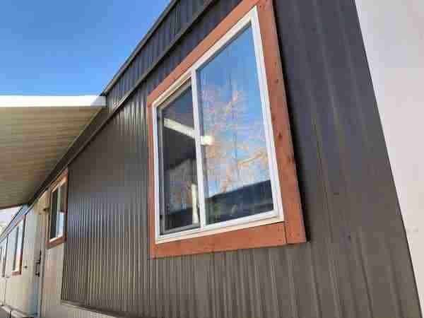 the side of a house with a large window and siding on it's sides