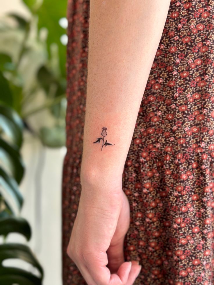 a woman with a small tattoo on her left arm holding the hand of another person