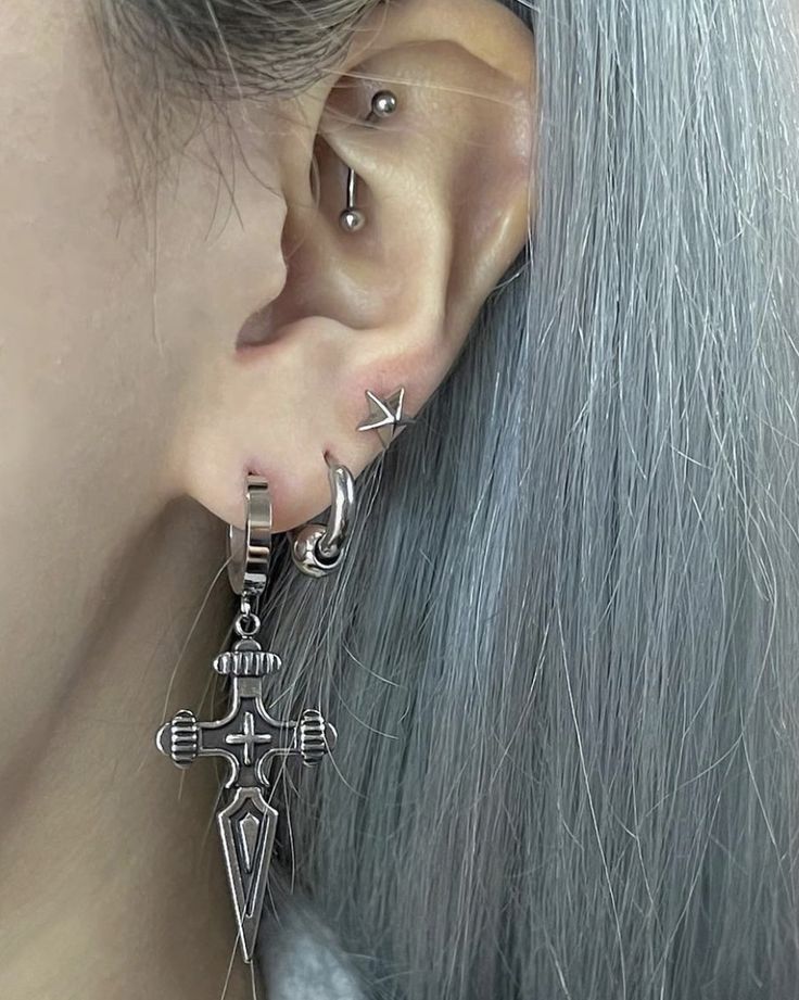 a woman with grey hair wearing silver earring and piercings on her left ear