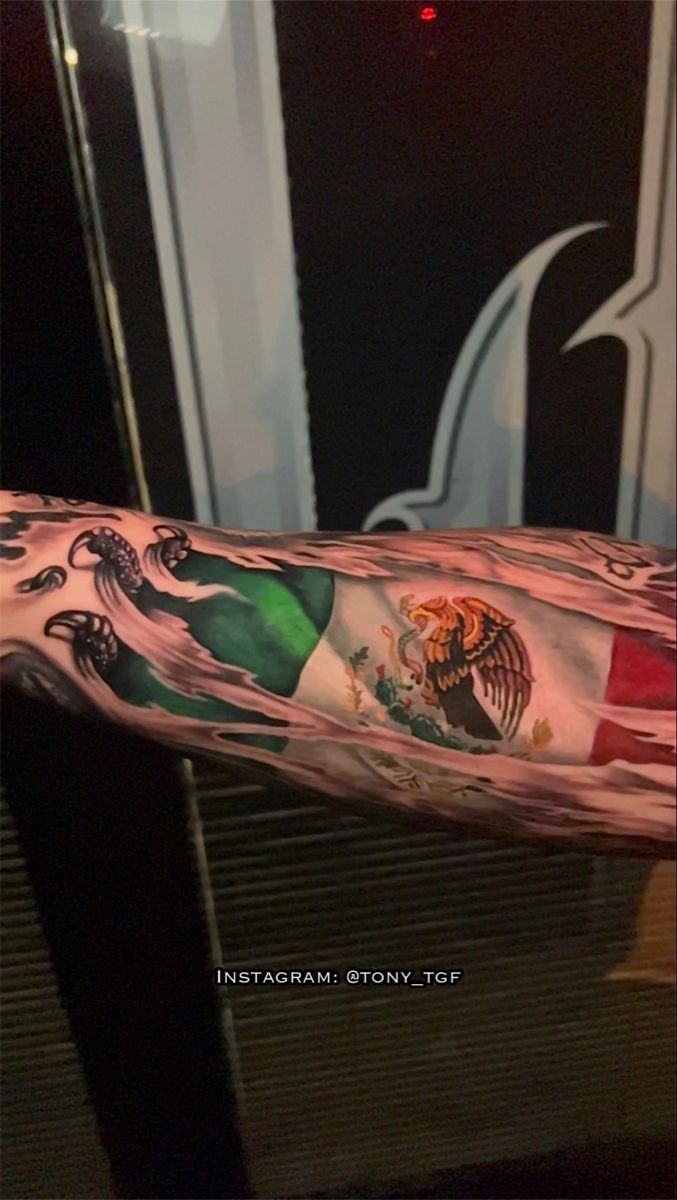 a man's arm with an italian flag and eagle tattoo on the left forearm