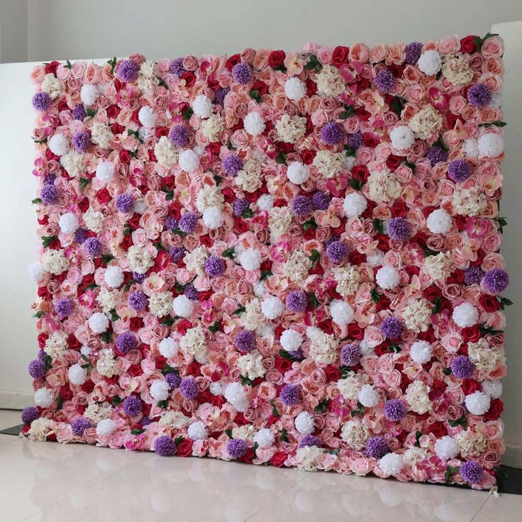 a pink and white flowered wall with pom - poms on the side