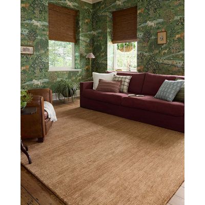 a living room with green wallpaper and brown rugs on top of the floor