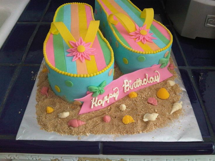 there is a birthday cake made to look like flip flops on the sand and beach