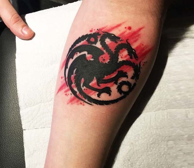 a person with a tattoo on their arm that has red paint splattered over it