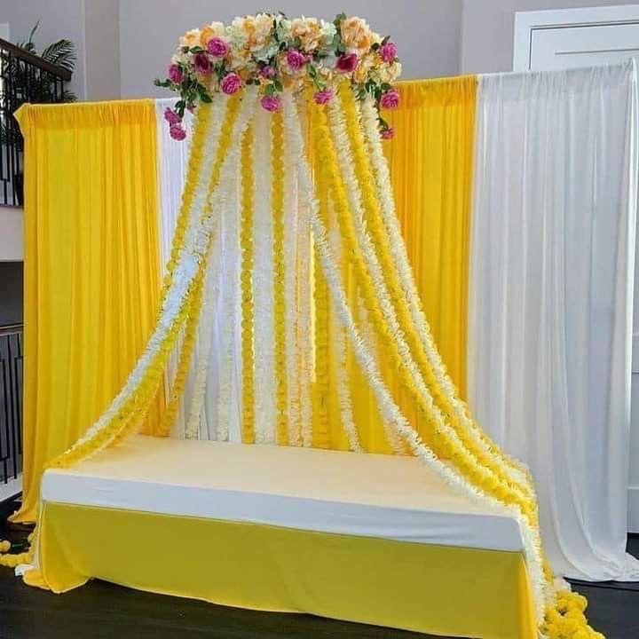 a bed covered in yellow drapes and flowers