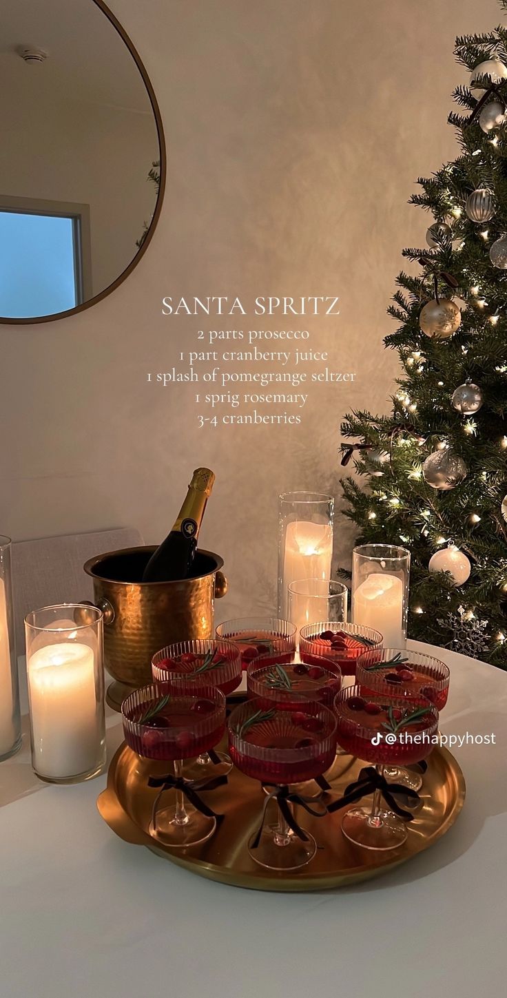 a table topped with candles next to a christmas tree and a wine bottle on top of a tray