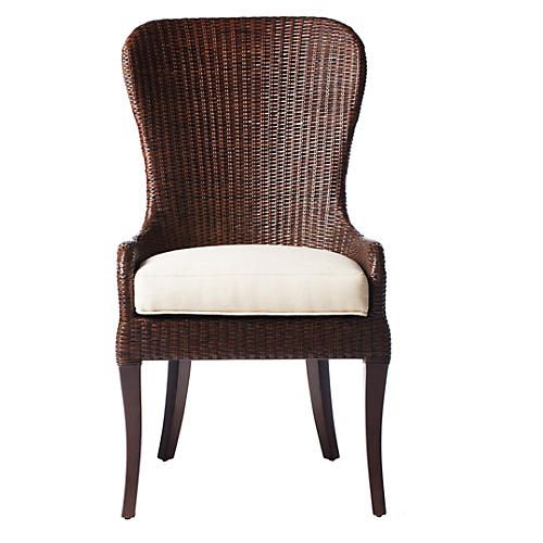 a wicker chair with a cushion on the back and armrests is shown in front of a white background