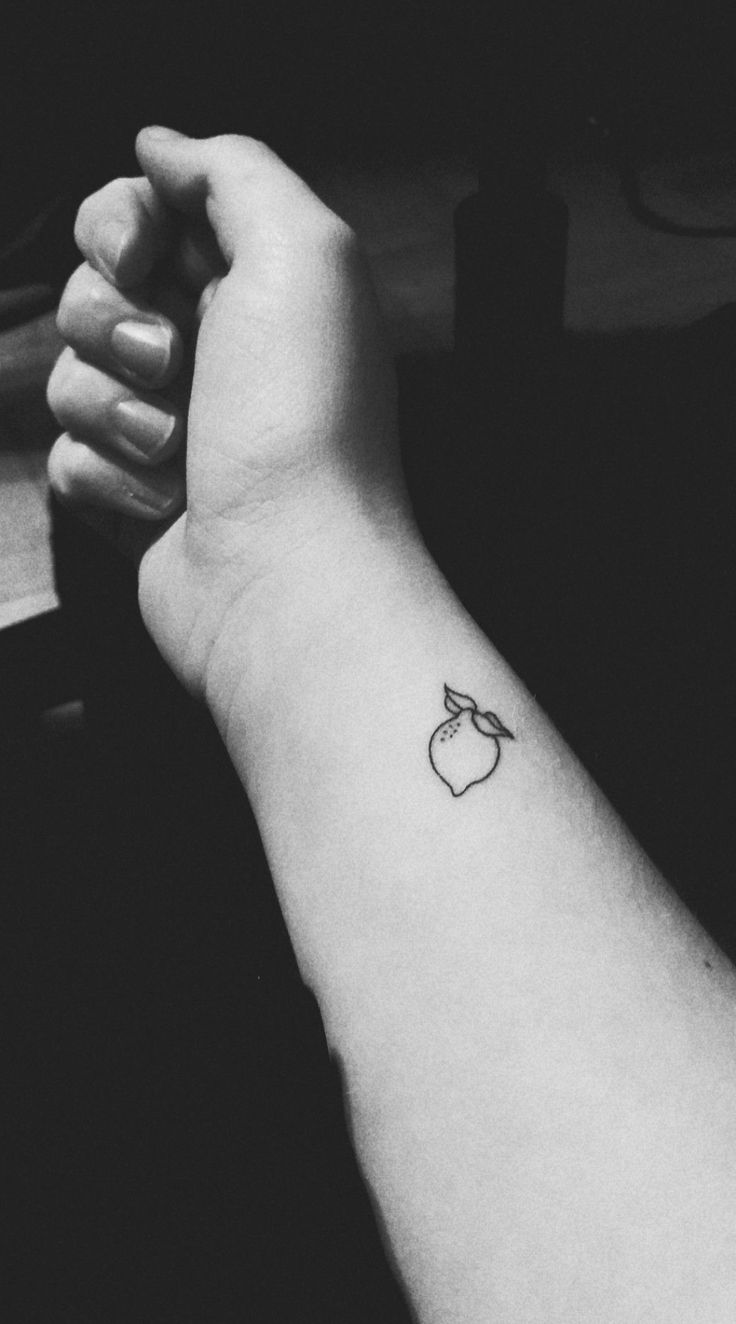 black and white photo of apple tattoo on the left arm, with an apple in the middle