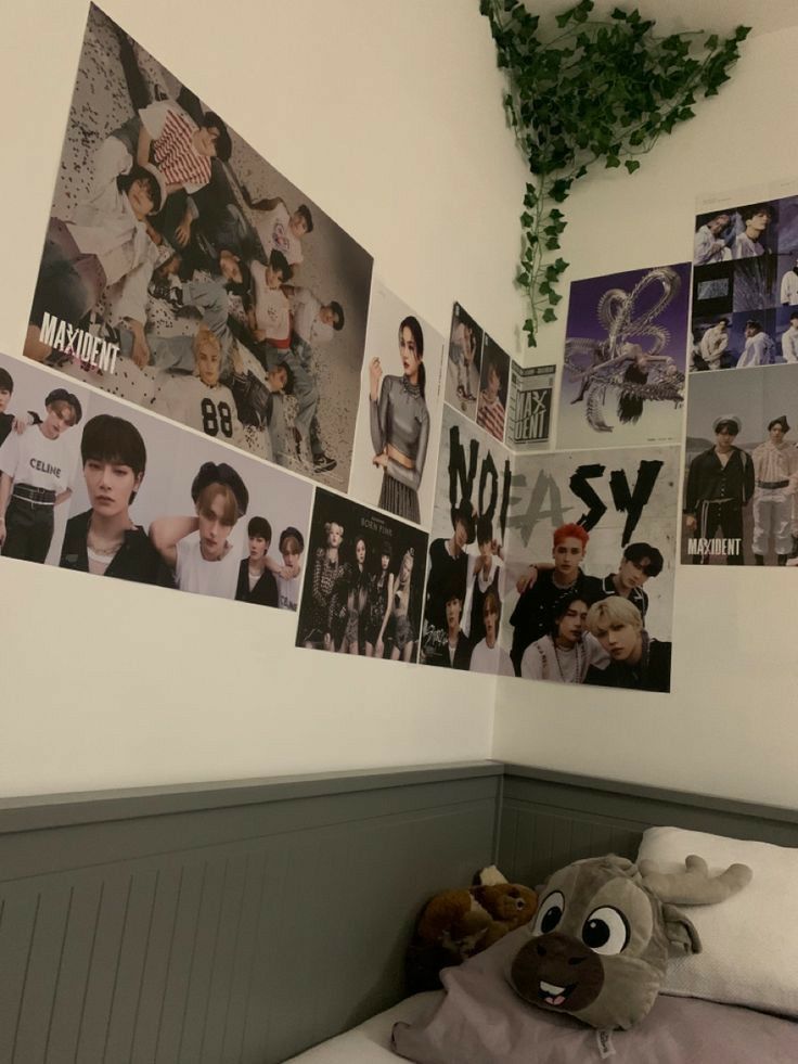 a bedroom with posters on the wall and a stuffed animal