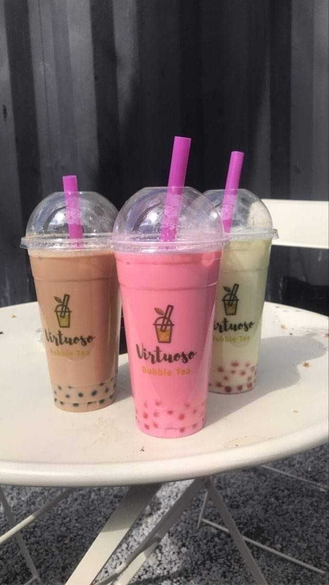 three drinks sitting on top of a white table next to each other in plastic cups