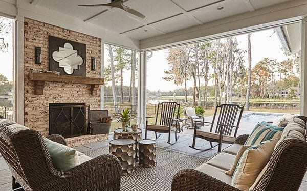 a living room filled with furniture and a fire place in front of a brick wall