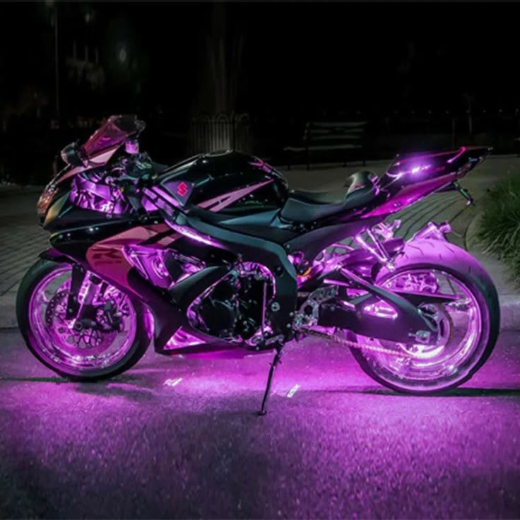 two motorcycles parked next to each other on the street in front of a building at night