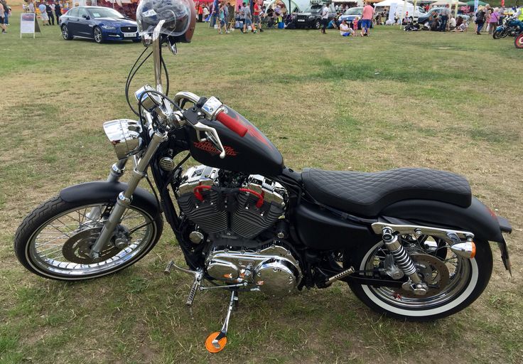 a motorcycle is parked on the grass in front of people