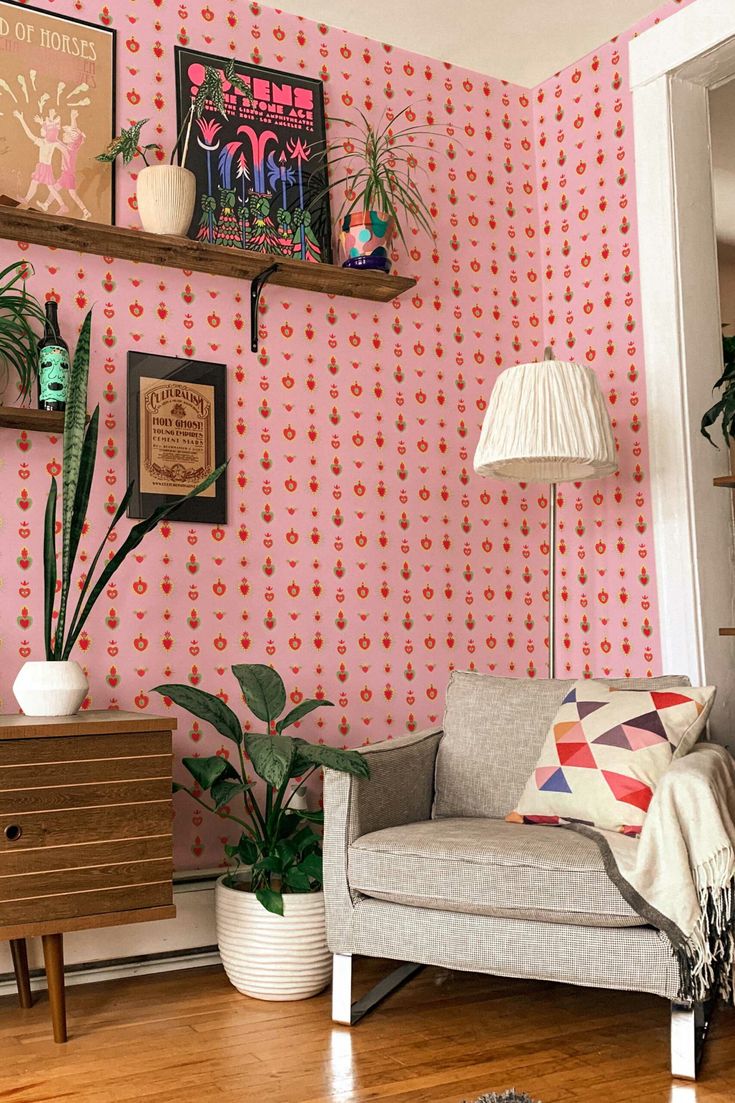 a living room with pink wallpaper and potted plants